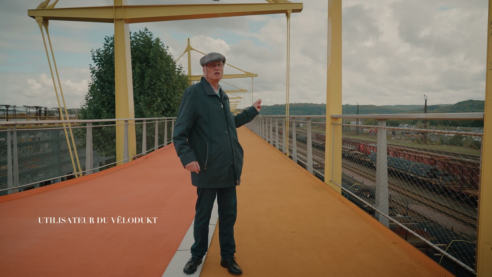 Un usager du Vëlodukt témoigne, debout sur la piste cyclable entre les mâts jaunes
